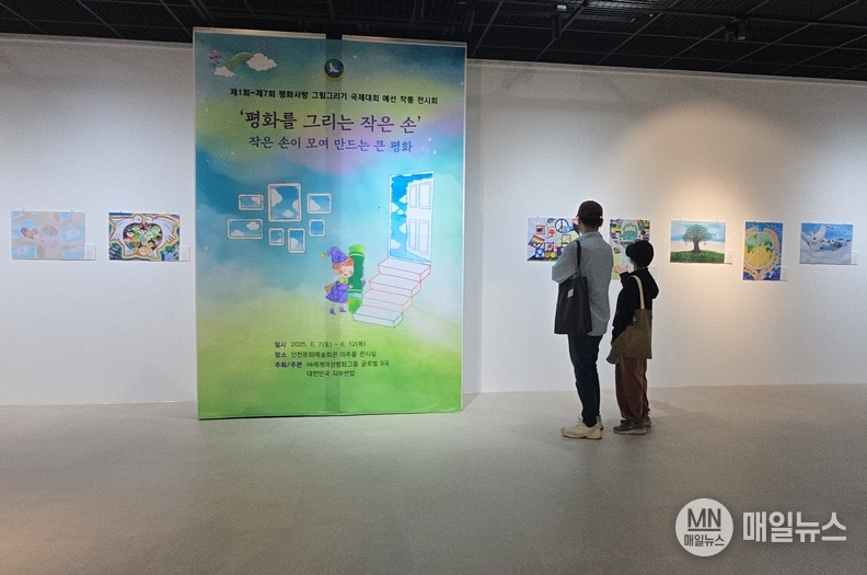 ‘평화를 그리는 작은 손’ 전시회에서 관람객이 그림을 감상하고 있다. ⓒ 김학현 편집부장