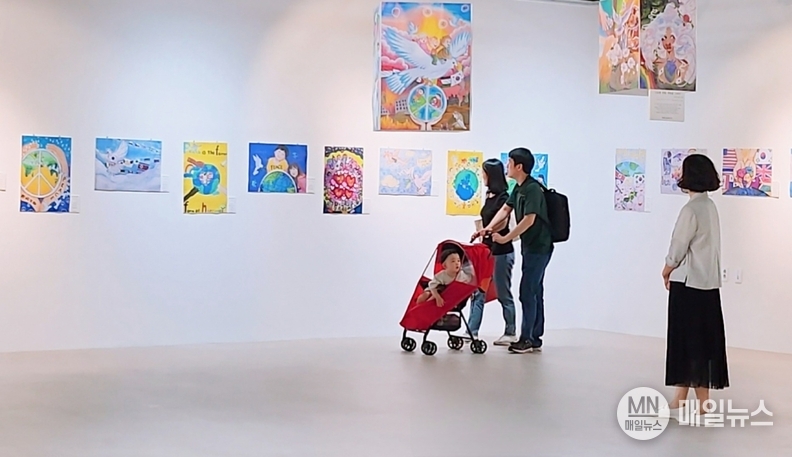 ‘평화를 그리는 작은 손’ 전시회에서 관람객이 그림을 감상하고 있다. ⓒ 김학현 편집부장