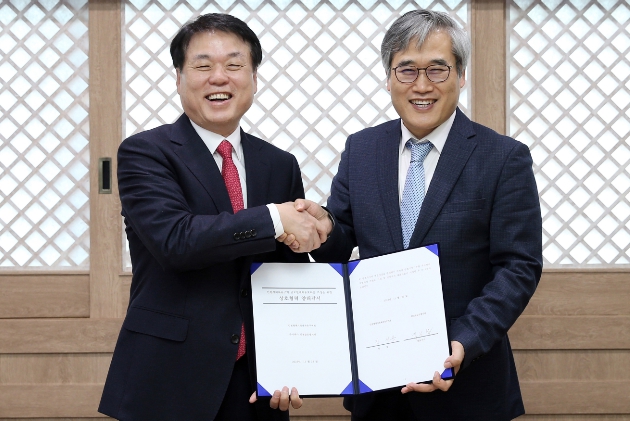 김진용 청장(오른쪽)이 백응섭 대표이사와 양해각서를 체결하고 악수하며 환하게 웃고 있다.