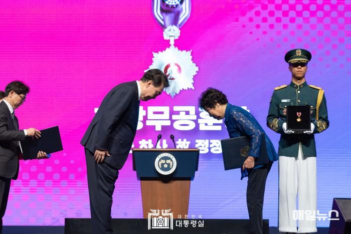 윤석열 대통령이 25일 대구 북구 엑스코에서 열린 6·25전쟁 74주년 행사에서 6·25전쟁 당시의 공적이 최근에 확인된 1사단 15연대 소속 고 정정태 하사의 동생 정정순 씨에게 화랑무공훈장을 수여한 뒤 인사하고 있다. ⓒ 대통령실 2.jpg