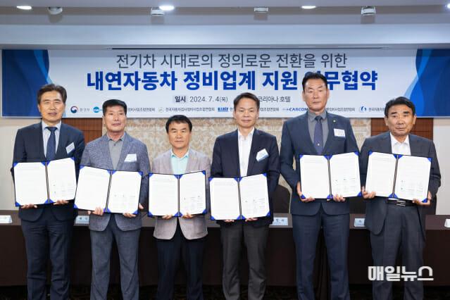 정종선 회장, 배덕환 회장, 강순근 회장, 이병화 차관, 곽영철 회장, 양승용 회장(왼쪽부터)이 4일 서울 광화문 코리아나호텔에서 ‘전기차 시대로의 정의로운 전환을 위한 내연차 정비업계 지원 업무협약’을 체결한 후 협약서를 들어보이고 있다. ⓒ 환경부 1.jpg
