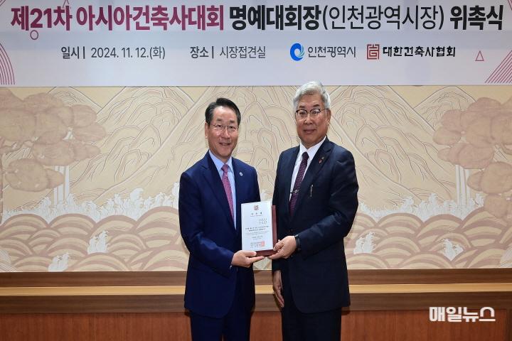 유정복 인천광역시장이 12일 시청 대접견실에서 열린 '제21차 아시아건축사대회 명예대회장(인천광역시장) 위촉식'에서 김재록 대한건축사협회 회장에게 위촉패를 받고 있다.0.jpg