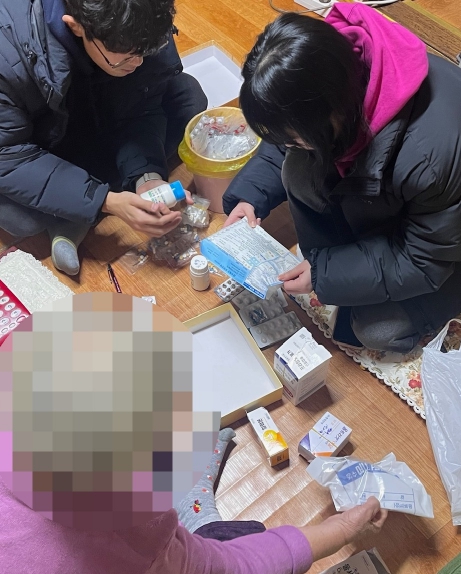 구로구 G밸리보건지소 건강동행팀이 어르신 가정에 방문해 올바른 복약 방법을 설명하고 있다.