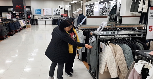 시민옹호인과 장애당사자가 지역상점에서 함께 옷을 고르는 모습