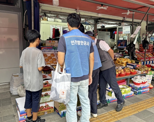 저소득 가정 아동과 함께 전통시장에서 장을 보고 있다.